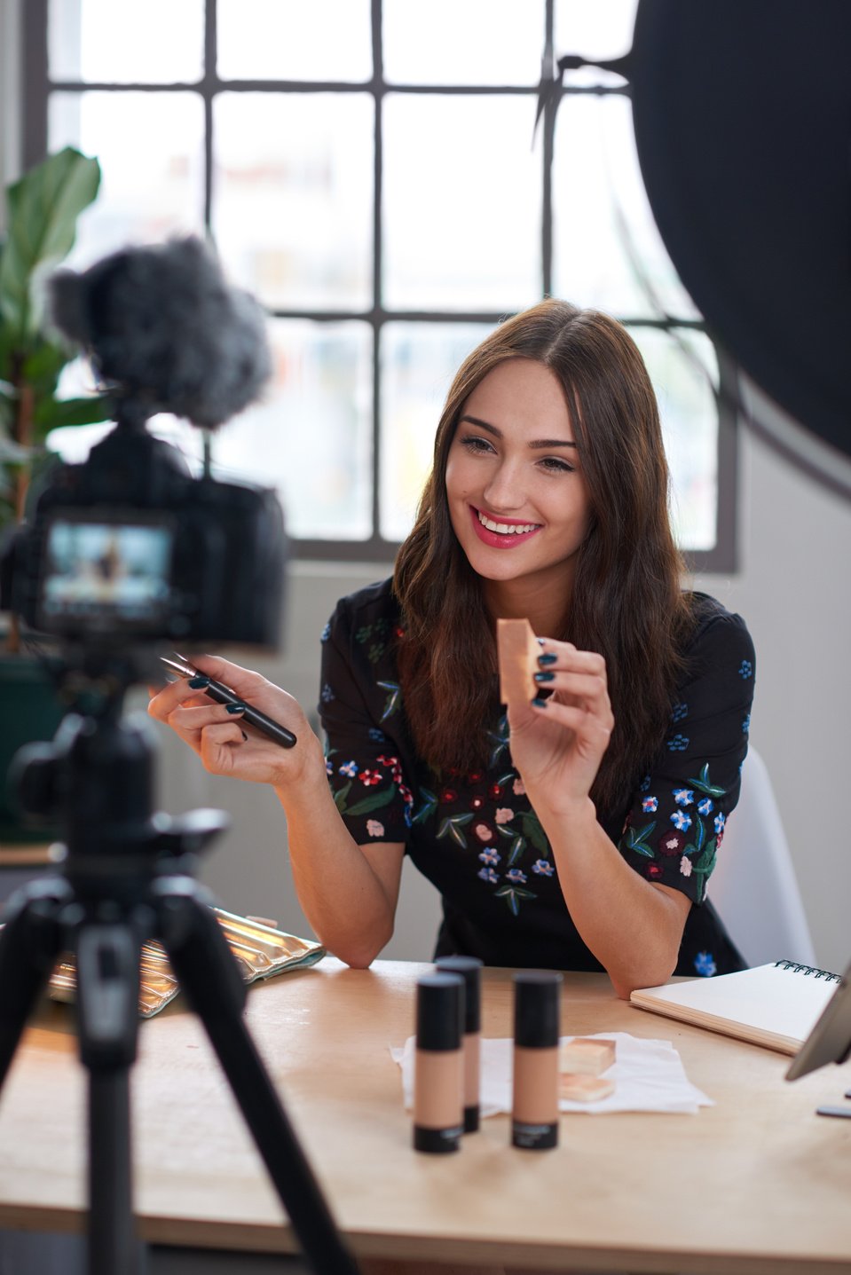 Beauty influencer recording a makeup review for her vlog